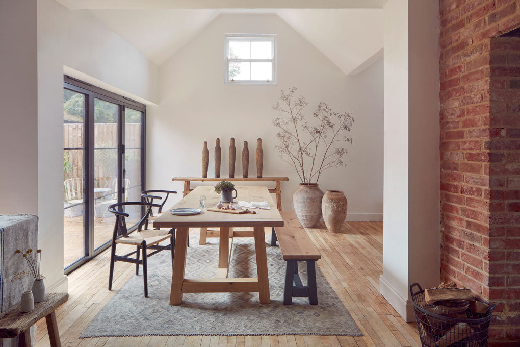 Home Barn’s rustic wooden dining table and bench with vintage ceramics in a neutral scheme
